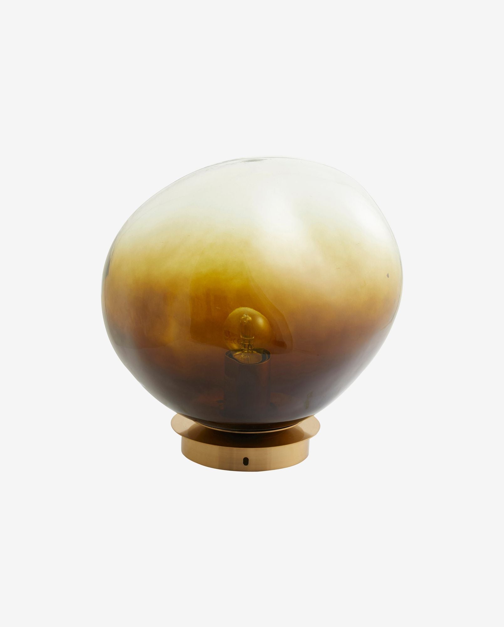 Modern amber glass table lamp with brass base and visible light bulb
