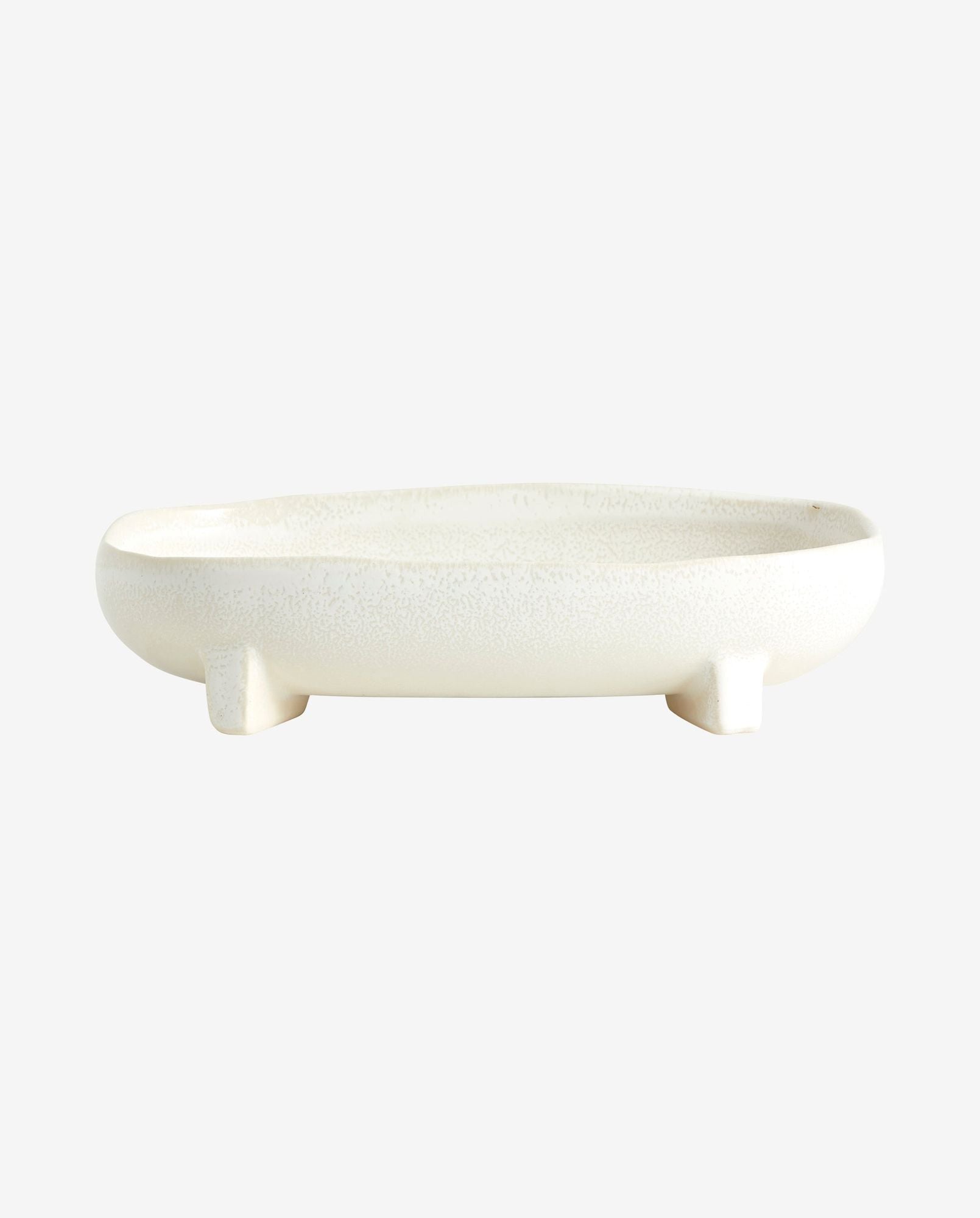 White oval ceramic dish with three small legs on a white background