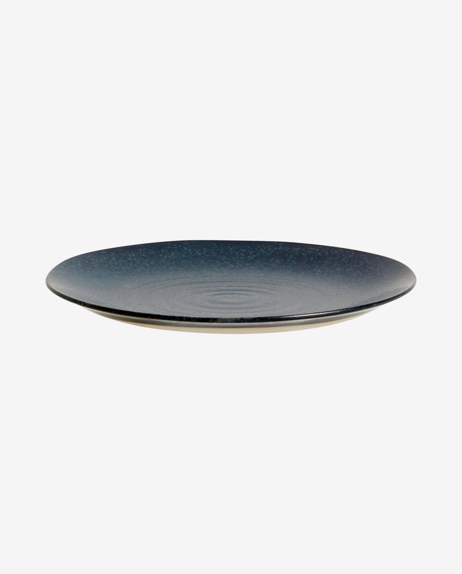 Round dark blue ceramic dinner plate with textured surface on white background