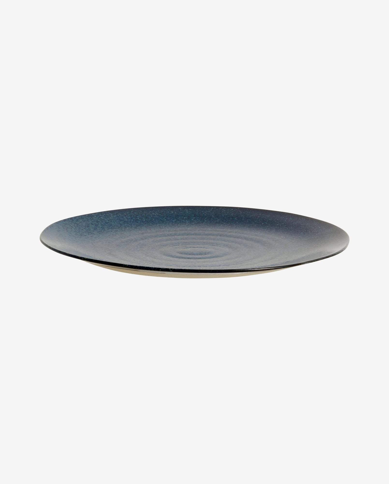 Dark blue ceramic dinner plate with textured concentric ring design on a white background