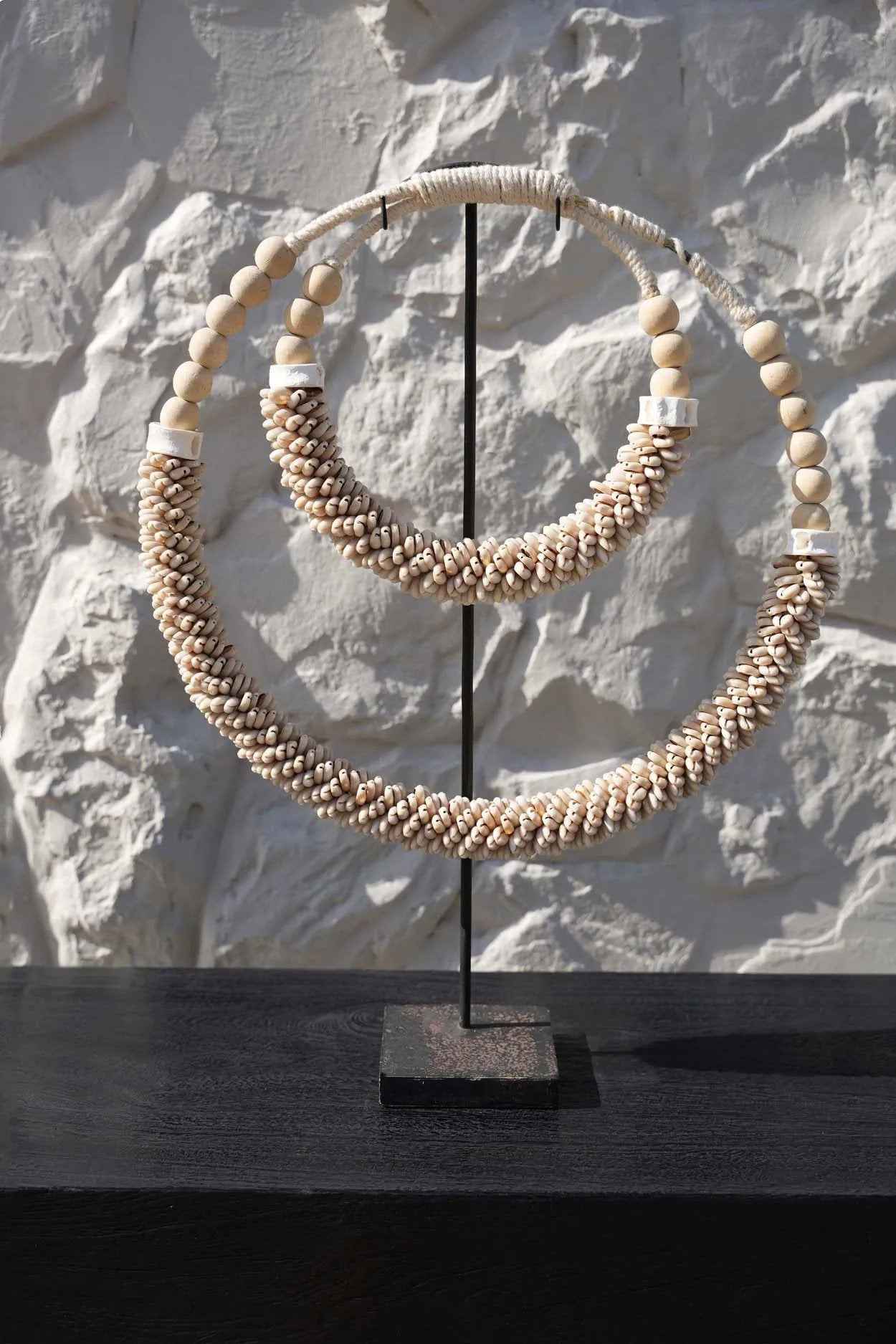 Handcrafted shell necklace decor on black stand