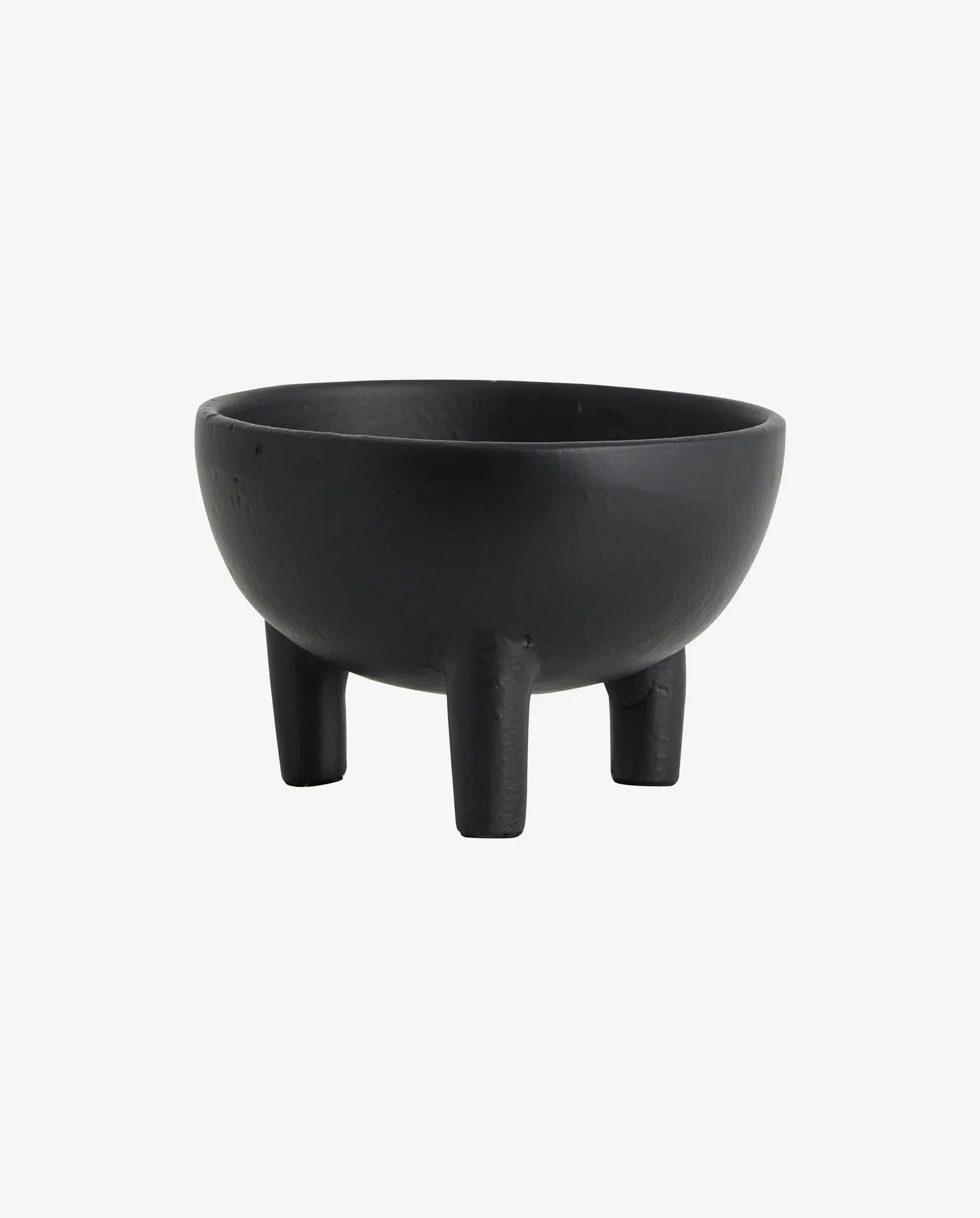 Black cast iron bowl with three sturdy legs on white background