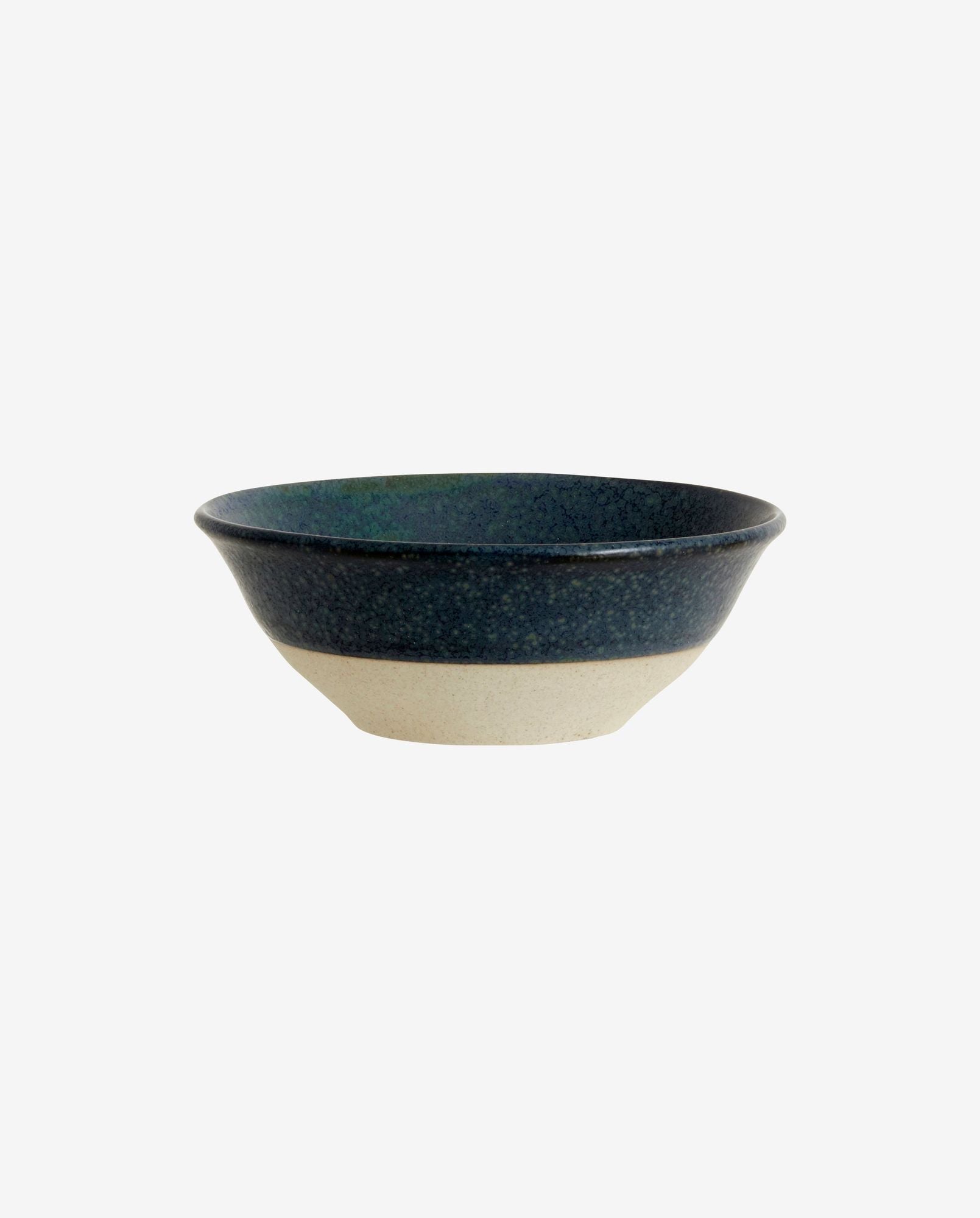 Ceramic bowl with dark speckled blue glaze and natural beige base on white background