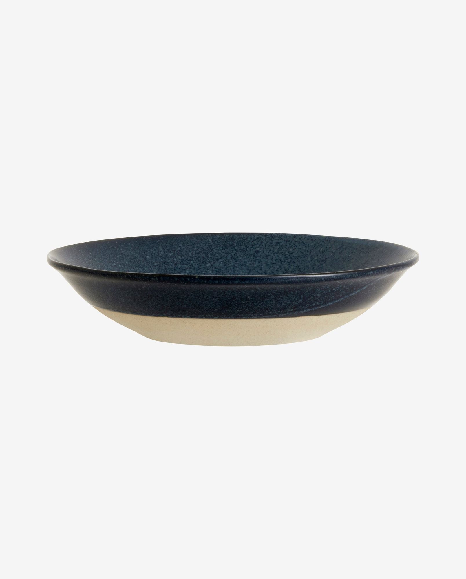 Side view of a ceramic bowl with black speckled interior and beige exterior on white background