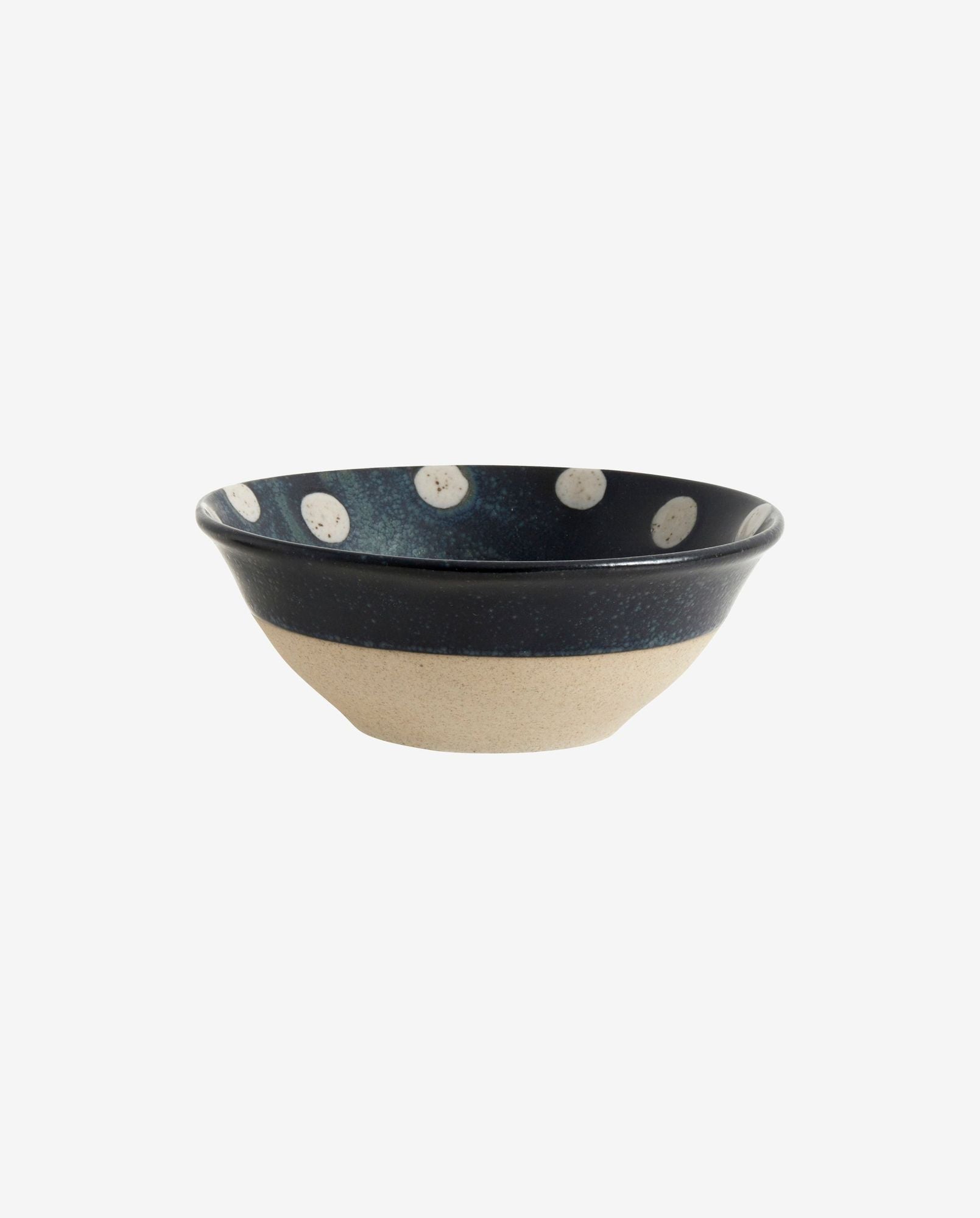 Ceramic bowl with beige bottom and dark blue top featuring white polka dots inside