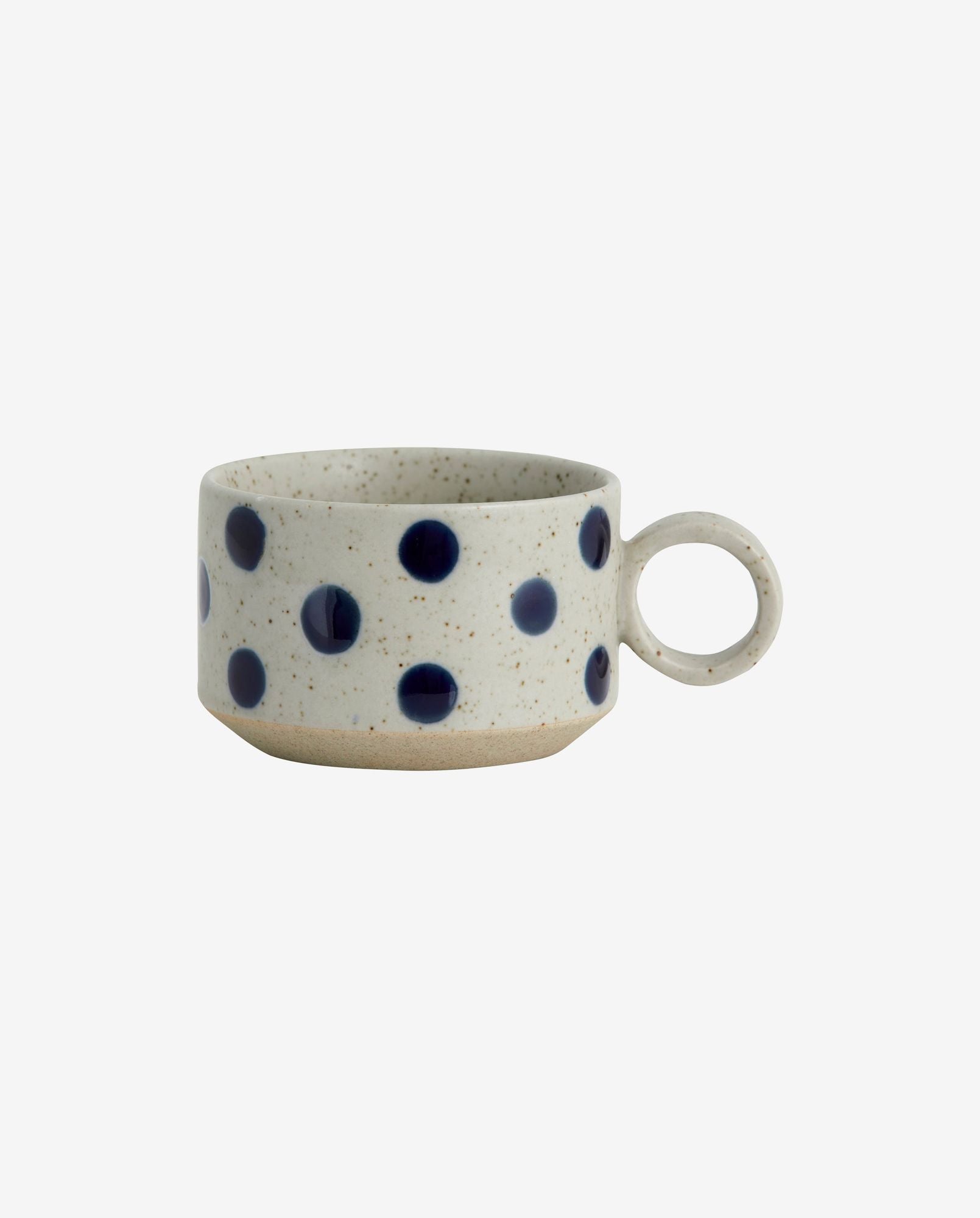 Speckled ceramic coffee cup with round handle and blue polka dot design on white background